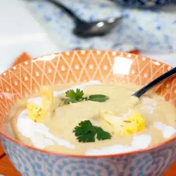 Orange cauliflower blender soup in a bowl.