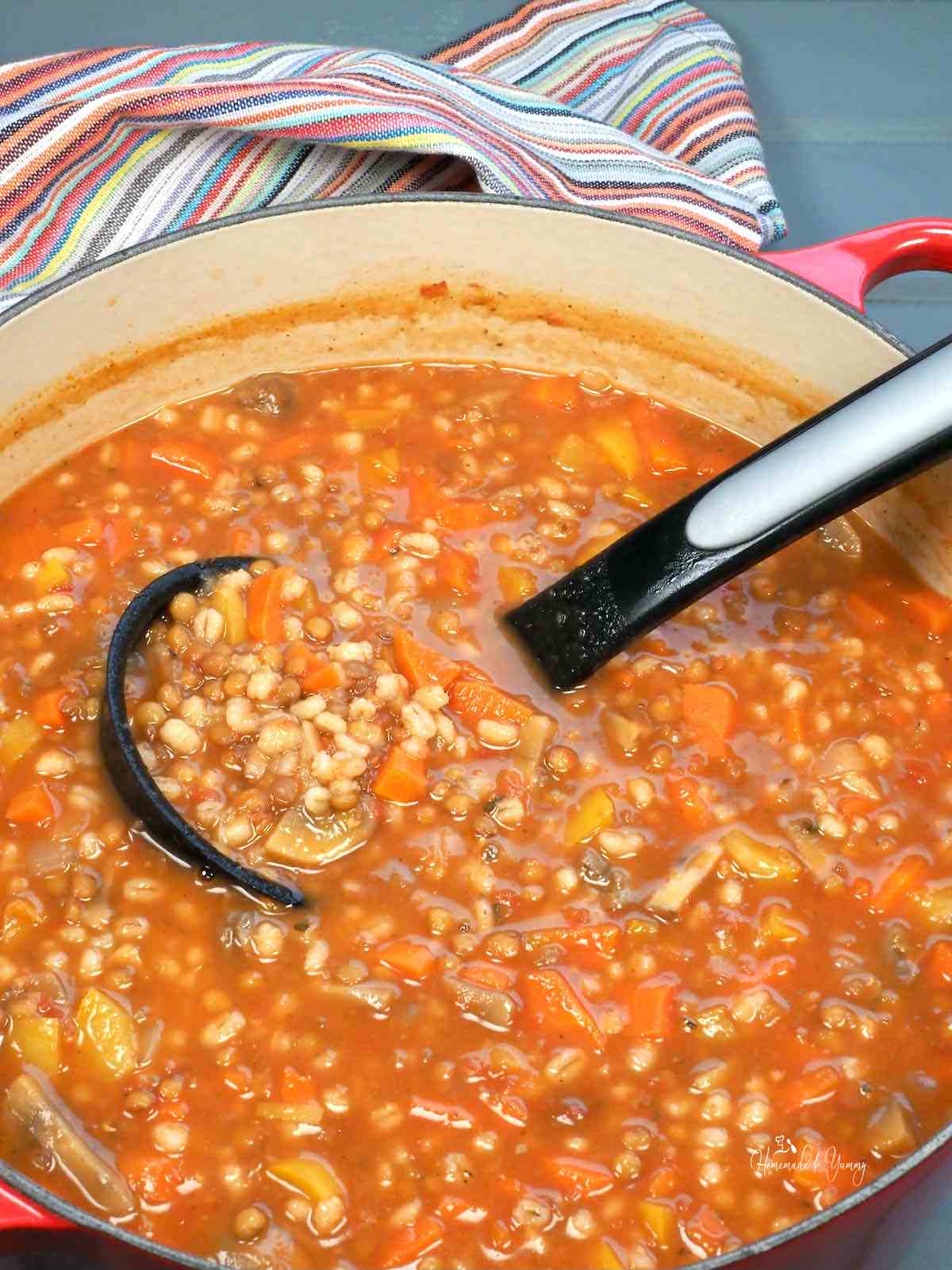 A pot of vegetable soup with lentils and barley.