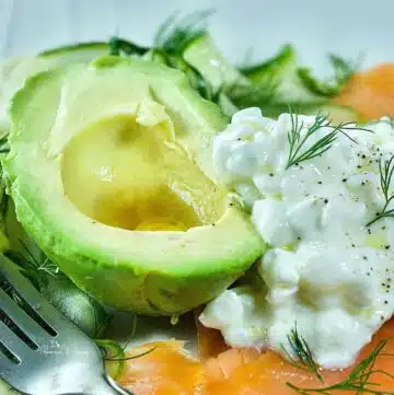 Cold smoked salmon plate for dinner with cottage cheese and avocado.