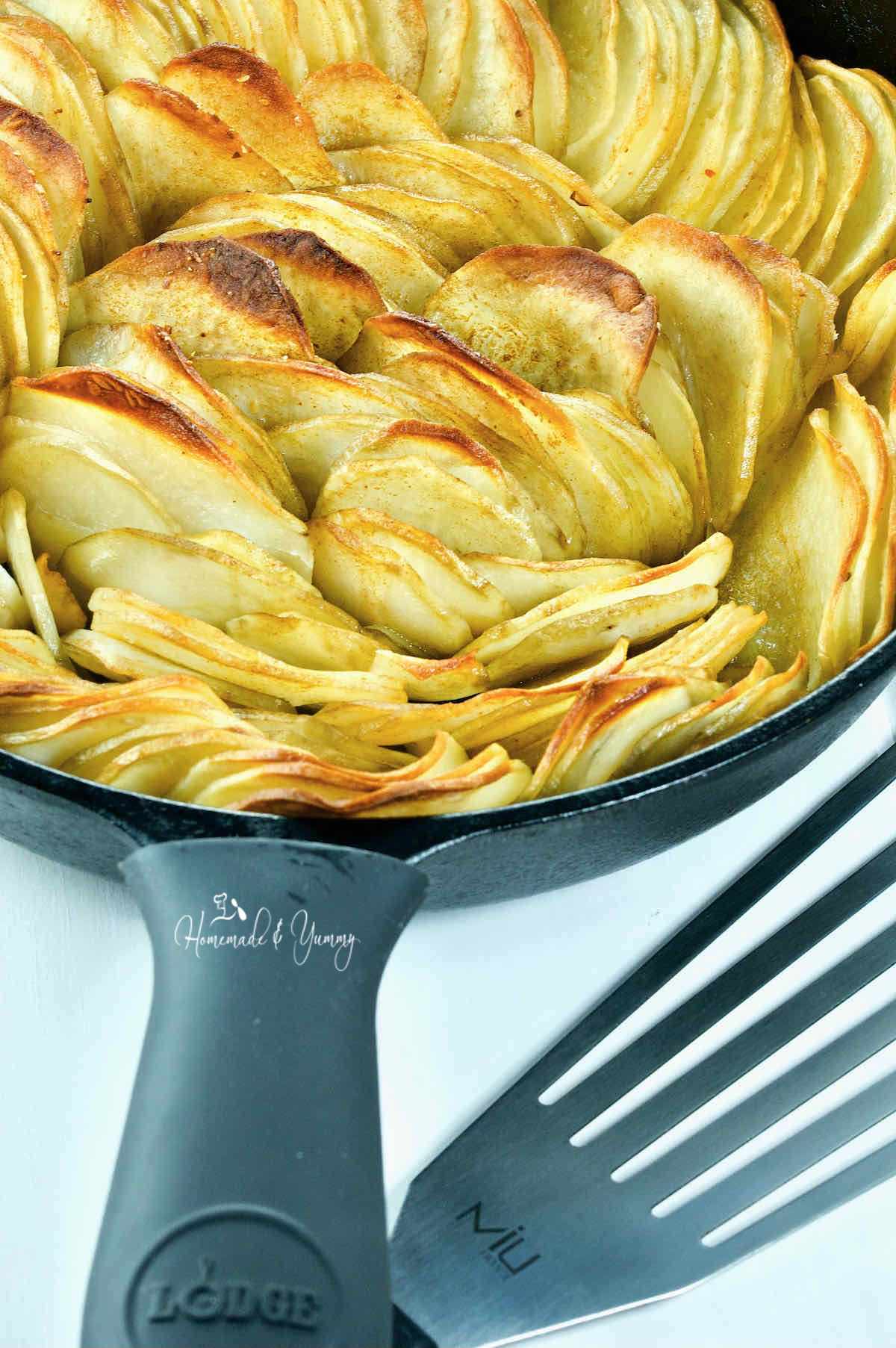 Sliced potatoes in a cast iron skillet.
