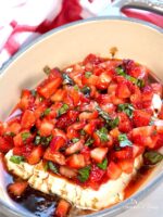Baked feta with balsamic strawberries in a serving dish.