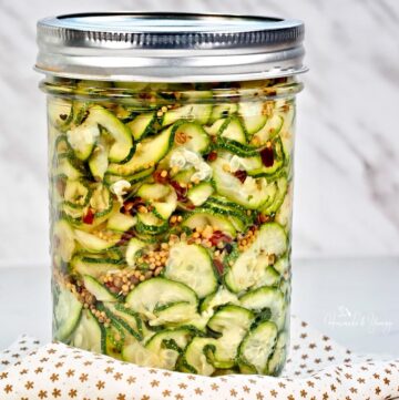 Quick pickled zucchini in a jar with spices.