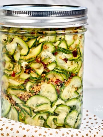 Quick pickled zucchini in a jar with spices.