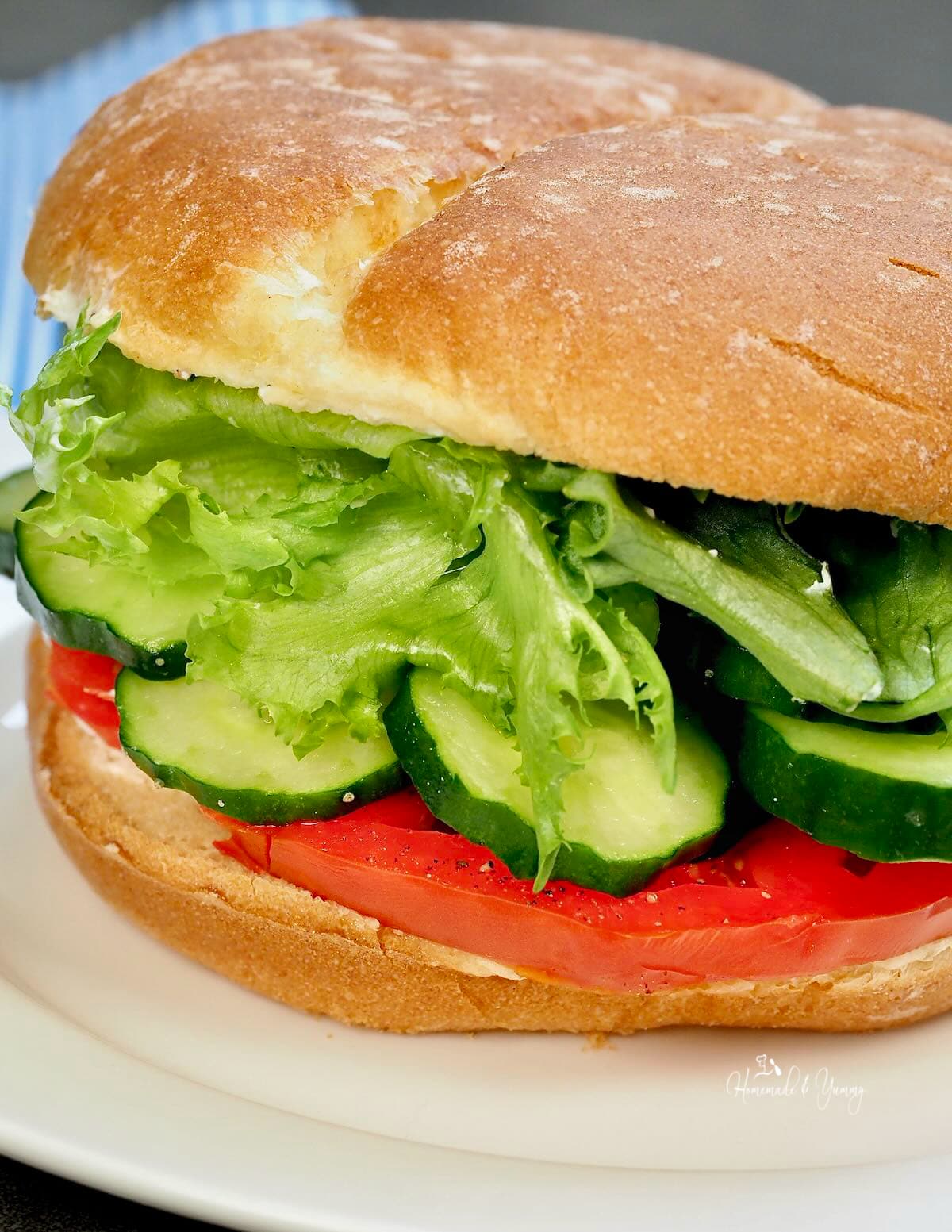 Cucumber and tomato sandwich with lettuce and mayo.