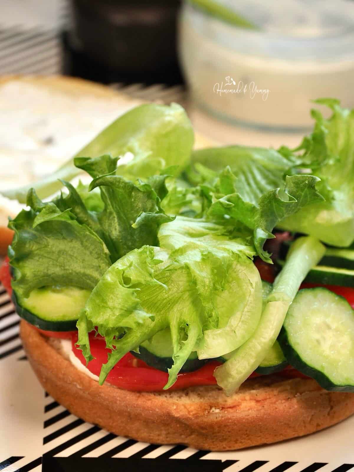 Lettuce on a tomato and cucumber sandwich.