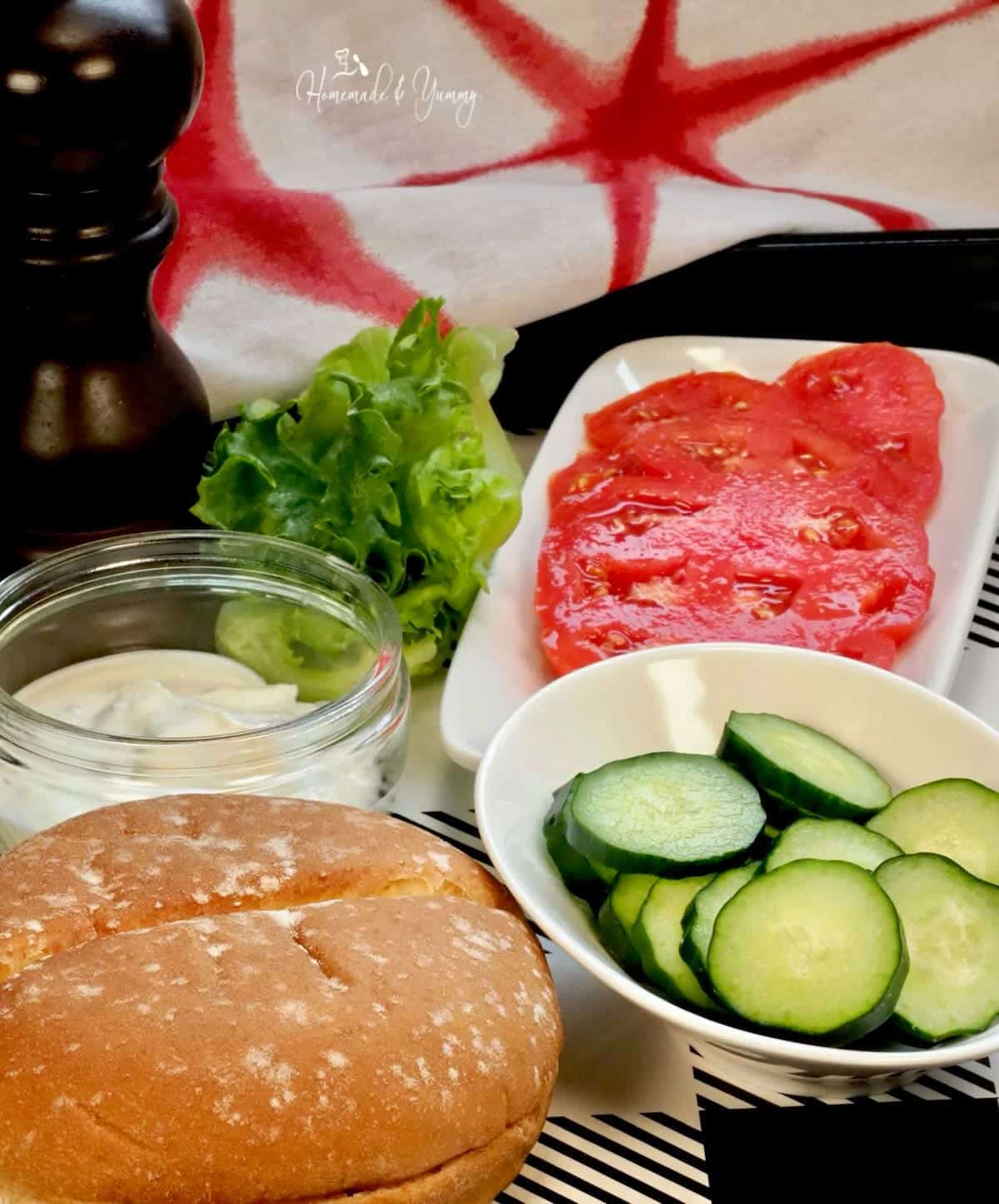 Ingredients to make a sandwich cucumbers and tomatoes.