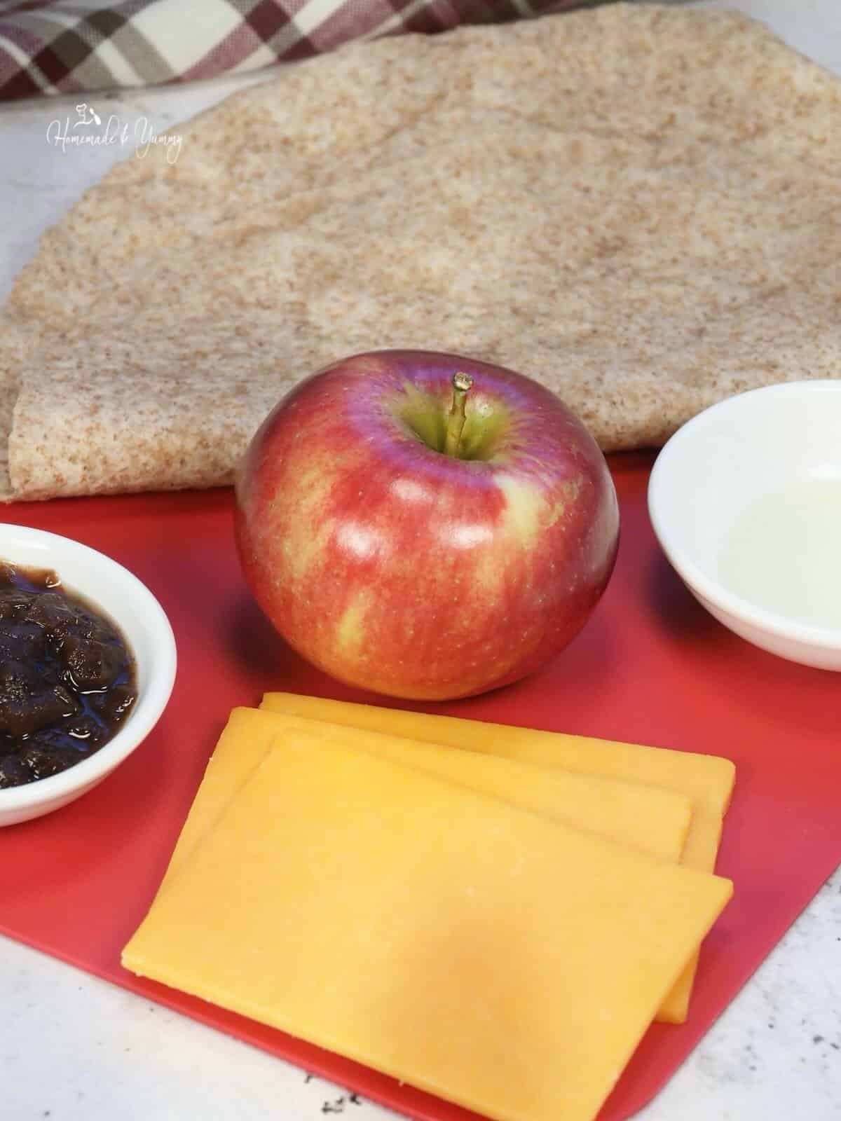 Ingredients to make a grilled quesadilla with apples and cheddar.